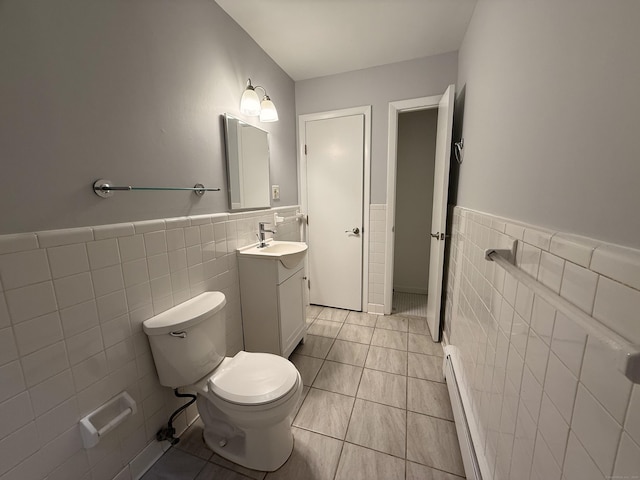 1105 Waterbury Rd Apt 1B, Cheshire, CT 06410 - bathroom featuring tile walls, vanity, wainscoting, a baseboard radiator, and tile patterned flooring