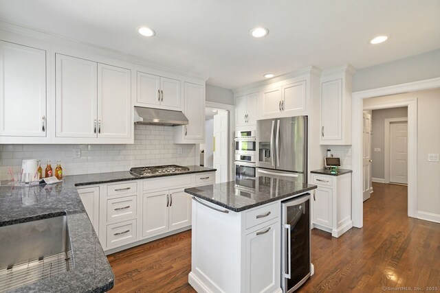 7 Sherwood Farms Ln, Westport, CT 06880 - kitchen with stainless steel appliances, beverage cooler, under cabinet range hood, white cabinetry, and backsplash