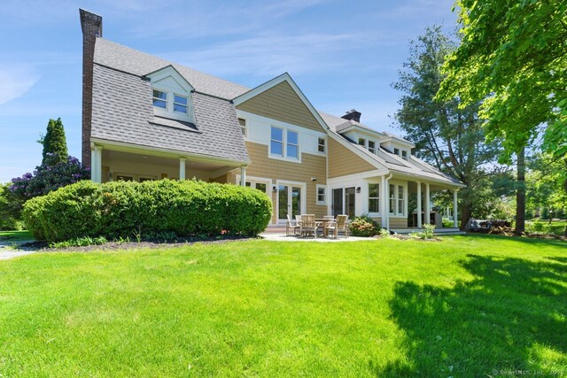 7 Sherwood Farms Ln, Westport, CT 06880 - back of house with a chimney, a lawn, a patio area, and roof with shingles