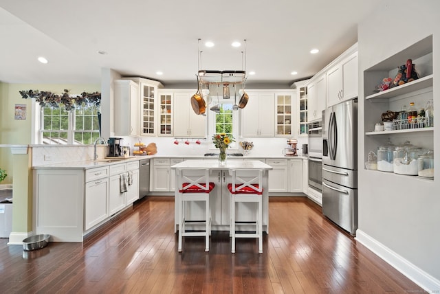 100 Pembroke Ter, Glastonbury, CT 06033 - kitchen with appliances with stainless steel finishes, a sink, a kitchen island, a kitchen bar, and white cabinets