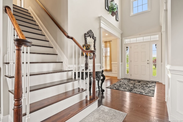 100 Pembroke Ter, Glastonbury, CT 06033 - foyer entrance featuring a towering ceiling, stairs, hardwood / wood-style flooring, a wainscoted wall, and a decorative wall