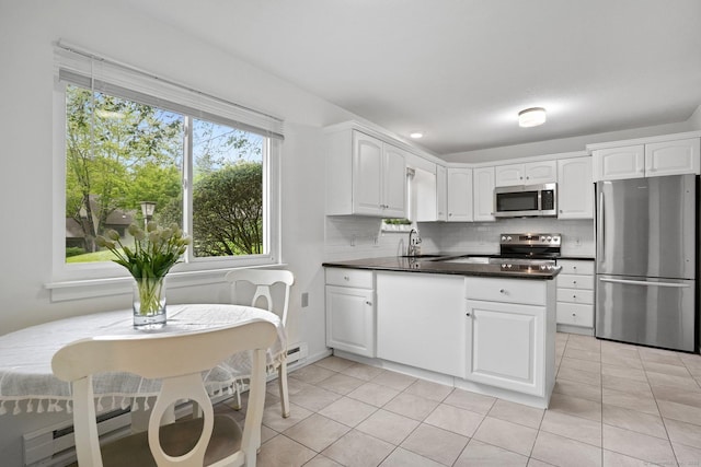 738 Heritage Vlg Unit B, Southbury, CT 06488 - kitchen featuring stainless steel appliances, a peninsula, dark countertops, white cabinetry, and tasteful backsplash