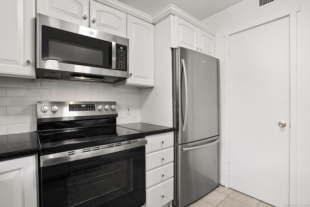 738 Heritage Vlg Unit B, Southbury, CT 06488 - kitchen featuring stainless steel appliances, white cabinets, tasteful backsplash, light tile patterned floors, and dark stone countertops