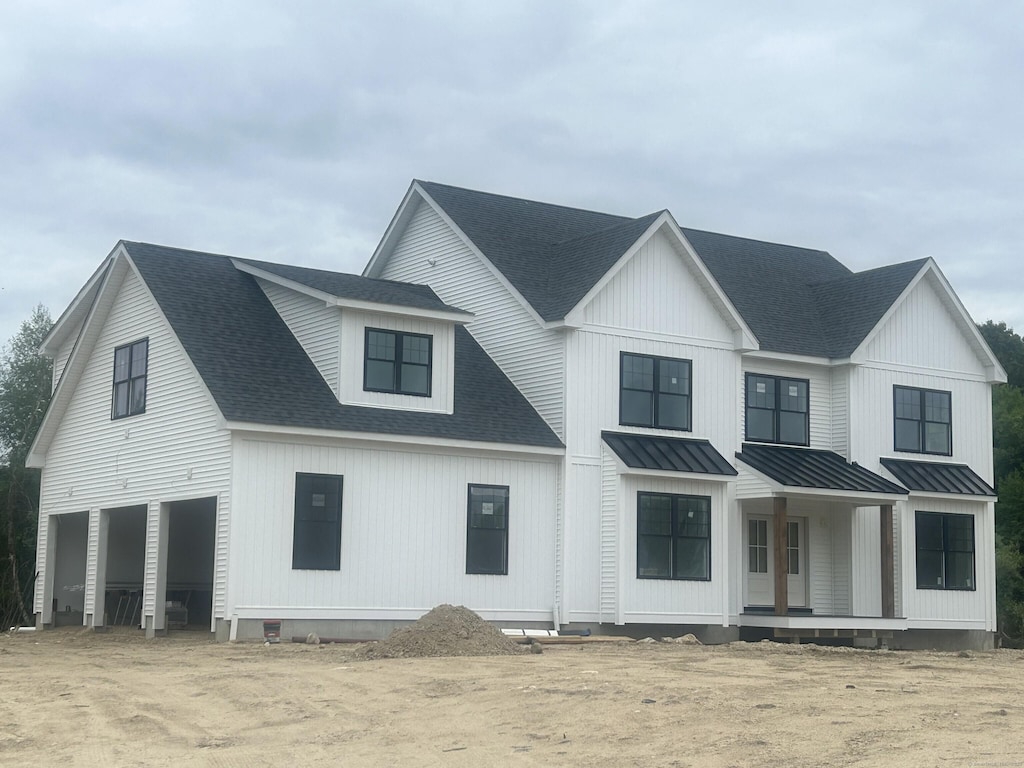 15 Rocco Dr, East Lyme, CT 06333 - modern farmhouse style home featuring a standing seam roof, metal roof, a shingled roof, and a porch