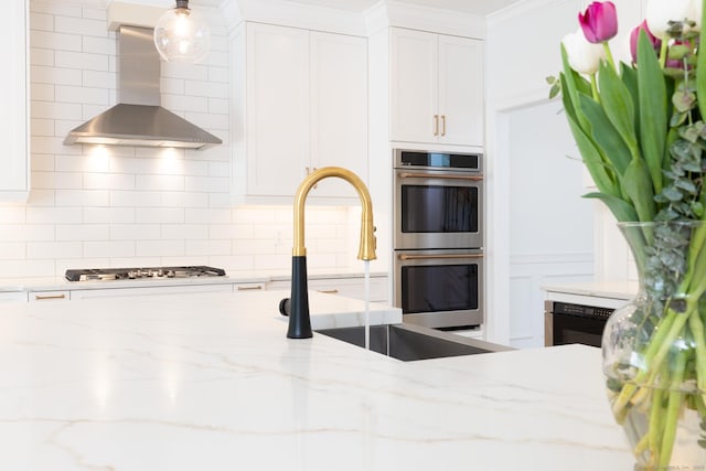 81 Nelson Dr, Burlington, CT 06013 - kitchen featuring wall chimney exhaust hood, stainless steel appliances, white cabinetry, and backsplash