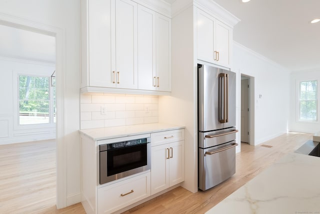 81 Nelson Dr, Burlington, CT 06013 - kitchen featuring freestanding refrigerator, crown molding, light wood-style flooring, plenty of natural light, and light stone counters