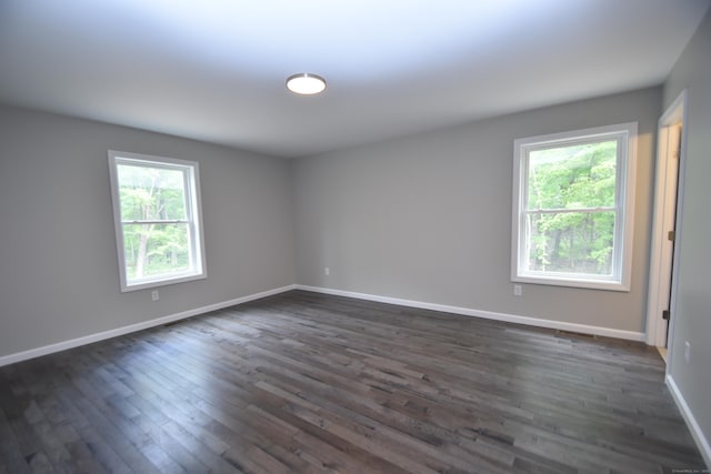 252 Plains Rd, Tolland, CT 06084 - empty room with healthy amount of natural light, dark wood-style flooring, and baseboards