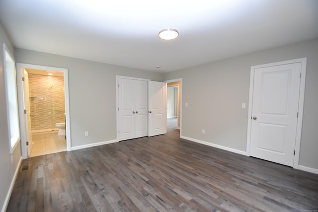 252 Plains Rd, Tolland, CT 06084 - unfurnished bedroom featuring baseboards, dark wood-style floors, ensuite bath, and a closet
