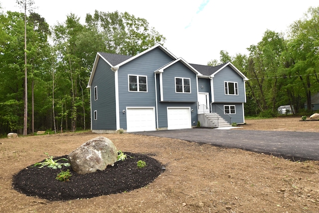 252 Plains Rd, Tolland, CT 06084 - bi-level home featuring asphalt driveway and a garage