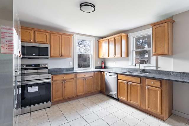 33 Prince St, Bristol, CT 06010 - kitchen with stainless steel appliances, a sink, light tile patterned floors, and dark stone counters
