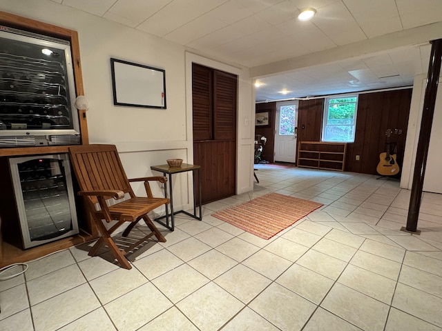 1 Russell Ln, Simsbury, CT 06070 - sitting room featuring beverage cooler, light tile patterned flooring, and wooden walls