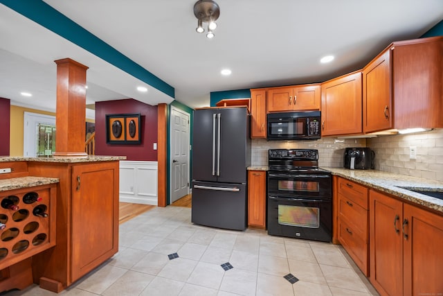 1 Russell Ln, Simsbury, CT 06070 - kitchen with black appliances, brown cabinets, light stone countertops, recessed lighting, and a wainscoted wall