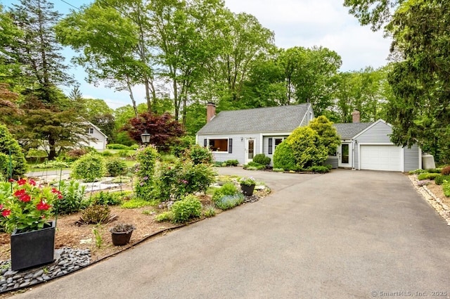 1 Russell Ln, Simsbury, CT 06070 - view of front of home featuring a chimney, an attached garage, and asphalt driveway