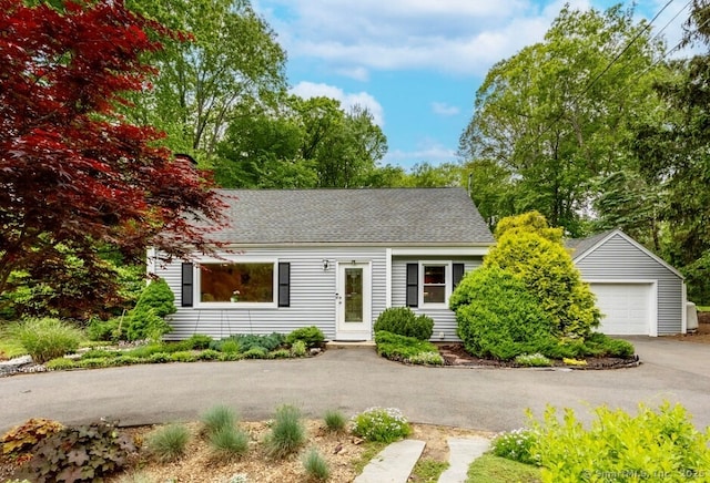 1 Russell Ln, Simsbury, CT 06070 - view of front of home with asphalt driveway, a detached garage, and roof with shingles