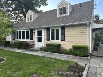 16 Neponsit St, Stamford, CT 06902 - new england style home with a front lawn, a shingled roof, and cooling unit