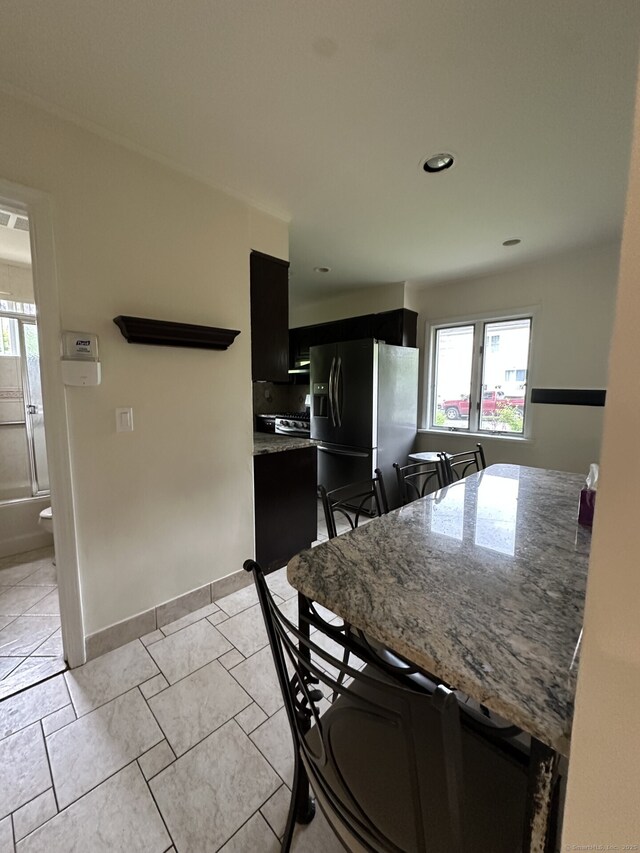16 Neponsit St, Stamford, CT 06902 - kitchen featuring refrigerator with ice dispenser, dark cabinets, healthy amount of natural light, light stone counters, and recessed lighting