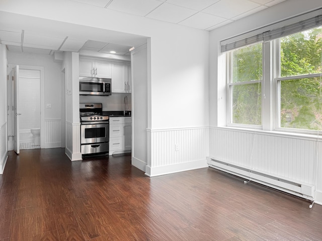 70 Strawberry Hill Ave Unit 5Gr4, Stamford, CT 06902 - kitchen with appliances with stainless steel finishes, a baseboard radiator, dark wood finished floors, a sink, and white cabinetry