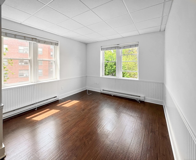 70 Strawberry Hill Ave Unit 5Gr4, Stamford, CT 06902 - unfurnished room with a baseboard heating unit, wainscoting, a paneled ceiling, and dark wood-style flooring
