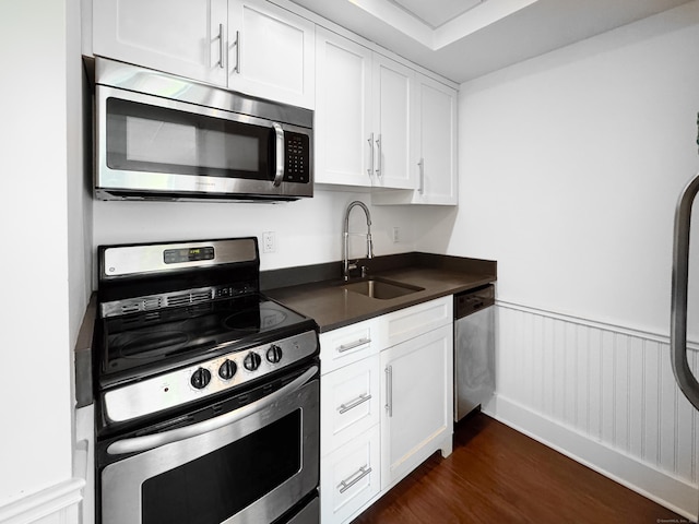 70 Strawberry Hill Ave Unit 5Gr4, Stamford, CT 06902 - kitchen featuring appliances with stainless steel finishes, a sink, dark countertops, dark wood-style flooring, and white cabinetry