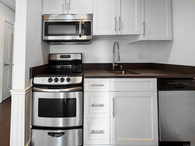70 Strawberry Hill Ave Unit 5Gr4, Stamford, CT 06902 - kitchen featuring stainless steel appliances, a sink, dark countertops, and white cabinetry
