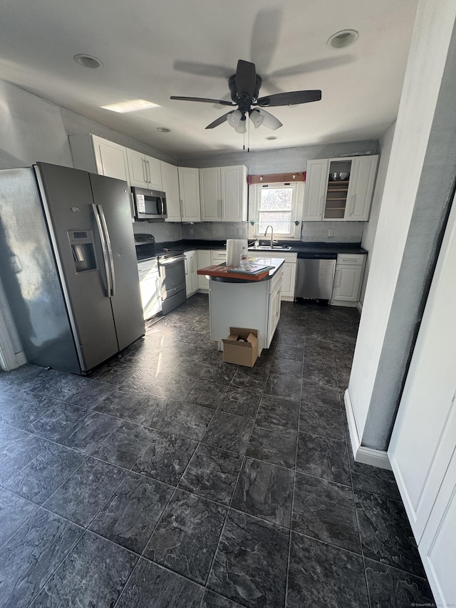 7 Carver Ave, Norwich, CT 06360 - kitchen featuring appliances with stainless steel finishes, a sink, white cabinets, a ceiling fan, and a center island