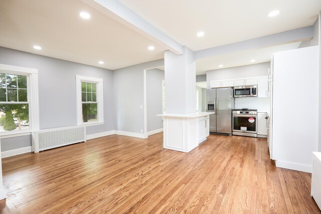 314 Skiff St, North Haven, CT 06473 - kitchen featuring stainless steel appliances, radiator, white cabinets, light wood-style flooring, and light countertops