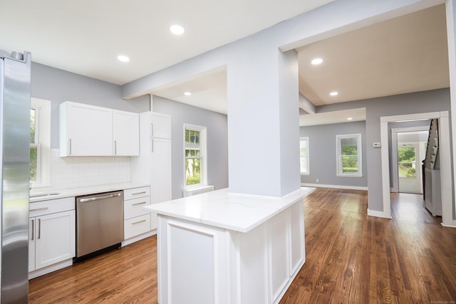 314 Skiff St, North Haven, CT 06473 - kitchen with appliances with stainless steel finishes, dark wood-style floors, decorative backsplash, light stone counters, and white cabinets
