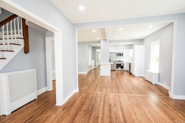 314 Skiff St, North Haven, CT 06473 - unfurnished living room featuring radiator heating unit, stairs, light wood-style floors, baseboards, and recessed lighting