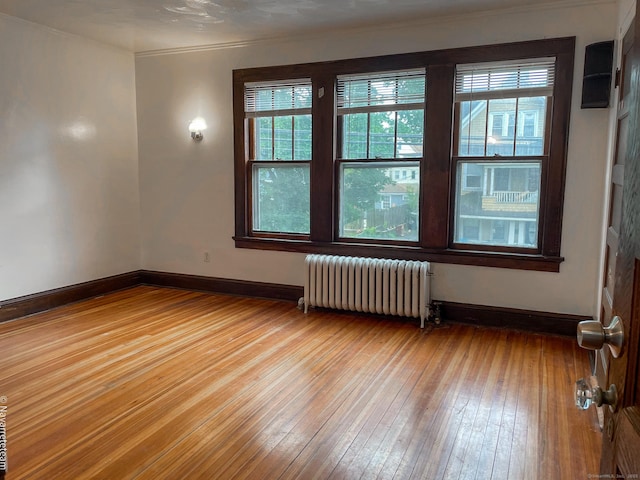 26 Stoehrs Pl, Bridgeport, CT 06606 - empty room with radiator heating unit, wood-type flooring, ornamental molding, and baseboards