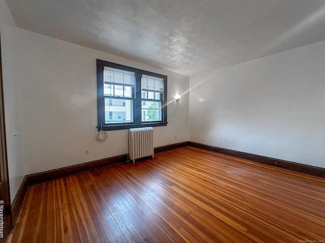 26 Stoehrs Pl, Bridgeport, CT 06606 - spare room with radiator heating unit, baseboards, and dark wood finished floors