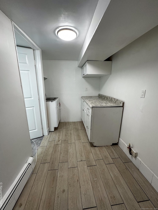 26 Stoehrs Pl, Bridgeport, CT 06606 - kitchen featuring baseboard heating, light wood-style flooring, white cabinetry, and light countertops
