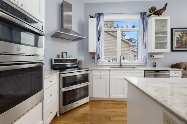 194 Killdeer Rd, Webster, MA 01570 - kitchen featuring a sink, wall chimney range hood, appliances with stainless steel finishes, and white cabinetry
