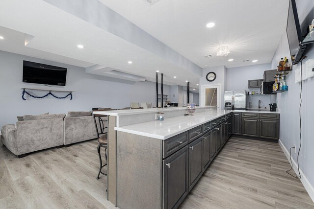 194 Killdeer Rd, Webster, MA 01570 - kitchen with open floor plan, a breakfast bar area, stainless steel fridge with ice dispenser, a peninsula, and light wood finished floors