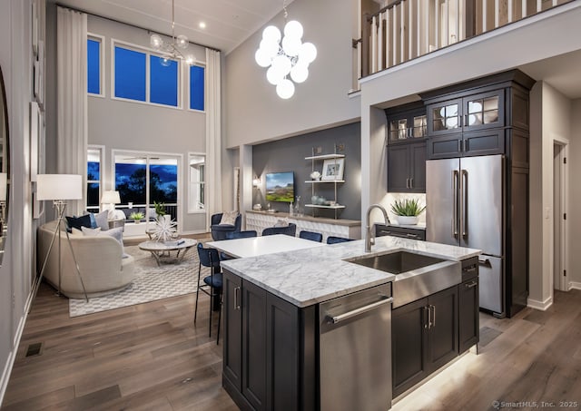 5 Heritage Ln Unit 68, Woodbridge, CT 06525 - kitchen featuring appliances with stainless steel finishes, open floor plan, a sink, a towering ceiling, and dark wood-style floors