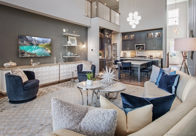 5 Heritage Ln Unit 68, Woodbridge, CT 06525 - living area with a high ceiling, a chandelier, and light wood-style floors