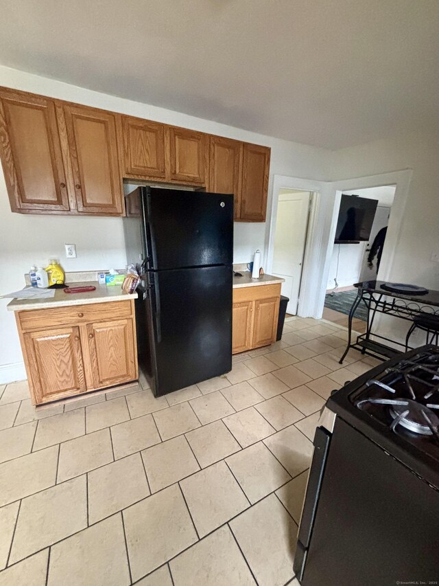 479 Broad St, Hartford, CT 06106 - kitchen featuring black appliances, light countertops, brown cabinets, and light tile patterned floors
