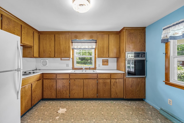 1 Pine Grove Ave, Enfield, CT 06082 - kitchen featuring freestanding refrigerator, black oven, a baseboard radiator, a sink, and brown cabinets