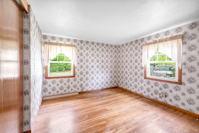1 Pine Grove Ave, Enfield, CT 06082 - empty room featuring a baseboard heating unit, wood finished floors, plenty of natural light, baseboards, and wallpapered walls