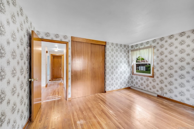1 Pine Grove Ave, Enfield, CT 06082 - unfurnished bedroom featuring baseboard heating, hardwood / wood-style flooring, a closet, wallpapered walls, and baseboards
