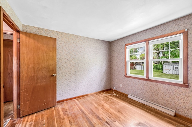 1 Pine Grove Ave, Enfield, CT 06082 - empty room featuring a baseboard radiator, light wood finished floors, wallpapered walls, and baseboards