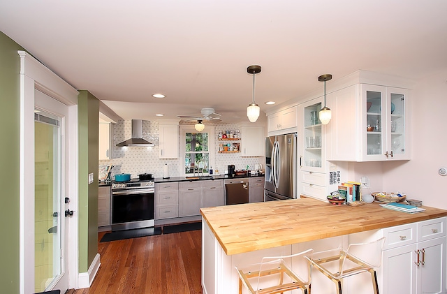 62 Mather St, Manchester, CT 06042 - kitchen featuring appliances with stainless steel finishes, wall chimney range hood, a peninsula, white cabinets, and glass insert cabinets