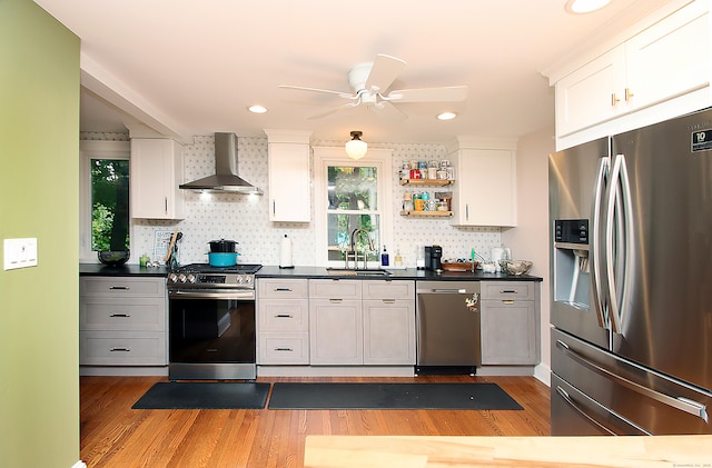 62 Mather St, Manchester, CT 06042 - kitchen featuring stainless steel appliances, wall chimney range hood, a sink, light wood-style flooring, and ceiling fan