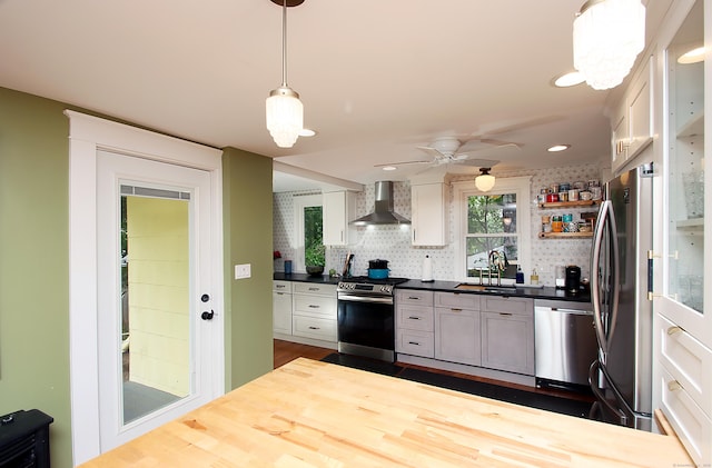62 Mather St, Manchester, CT 06042 - kitchen featuring wall chimney range hood, appliances with stainless steel finishes, decorative backsplash, a ceiling fan, and decorative light fixtures