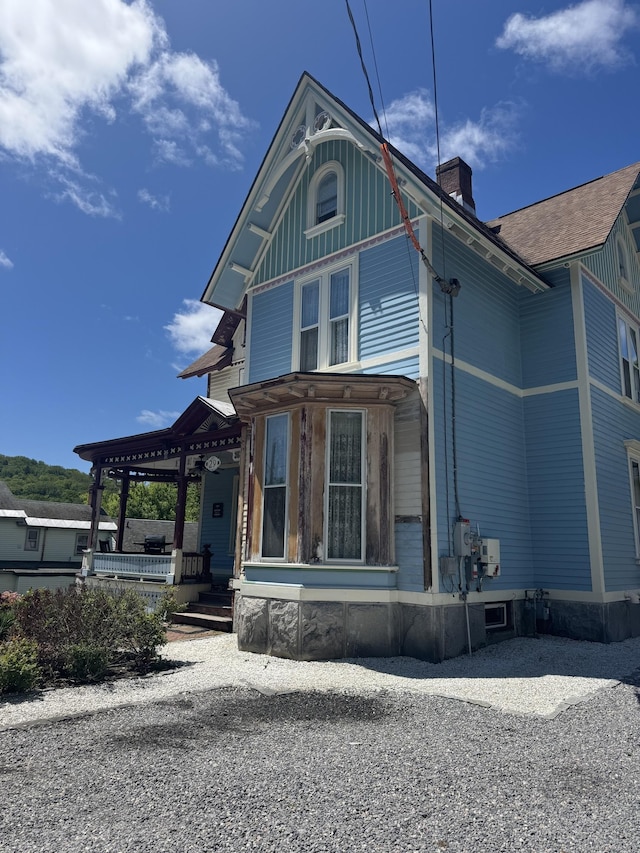 view of front of house featuring covered porch and a chimney