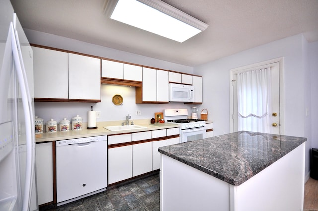 443 S Main St Unit 34, Manchester, CT 06040 - kitchen featuring white appliances, white cabinetry, a sink, a kitchen island, and stone finish flooring
