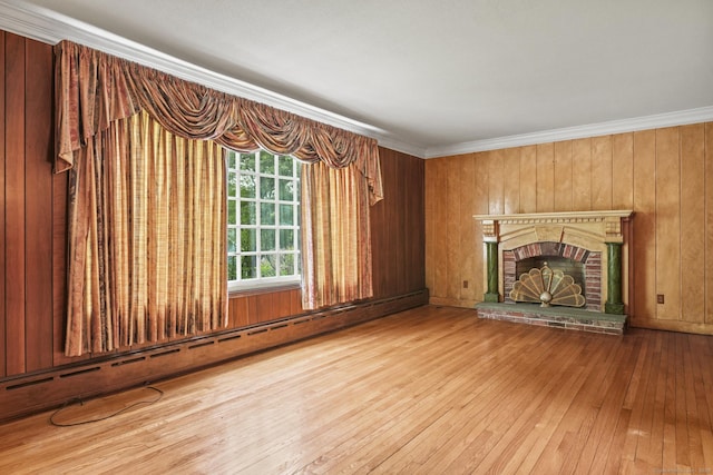 870 N Colony Rd, Meriden, CT 06450 - unfurnished living room featuring hardwood / wood-style floors, a baseboard radiator, a fireplace, ornamental molding, and wood walls