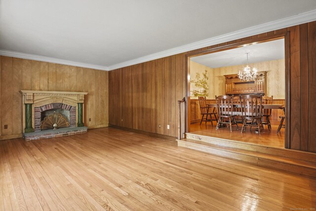 870 N Colony Rd, Meriden, CT 06450 - unfurnished living room with wood-type flooring, a chandelier, a brick fireplace, and crown molding