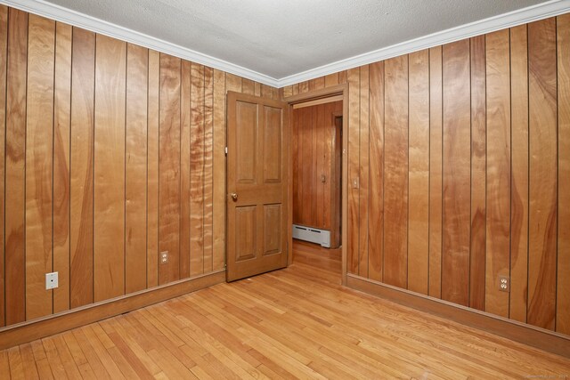 870 N Colony Rd, Meriden, CT 06450 - spare room with baseboard heating, hardwood / wood-style flooring, wood walls, a textured ceiling, and crown molding