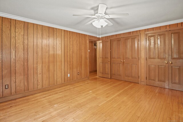 870 N Colony Rd, Meriden, CT 06450 - unfurnished bedroom featuring hardwood / wood-style flooring, two closets, wood walls, ceiling fan, and ornamental molding