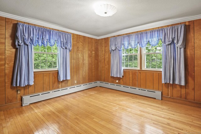 870 N Colony Rd, Meriden, CT 06450 - unfurnished room featuring hardwood / wood-style floors, crown molding, wood walls, baseboard heating, and a textured ceiling